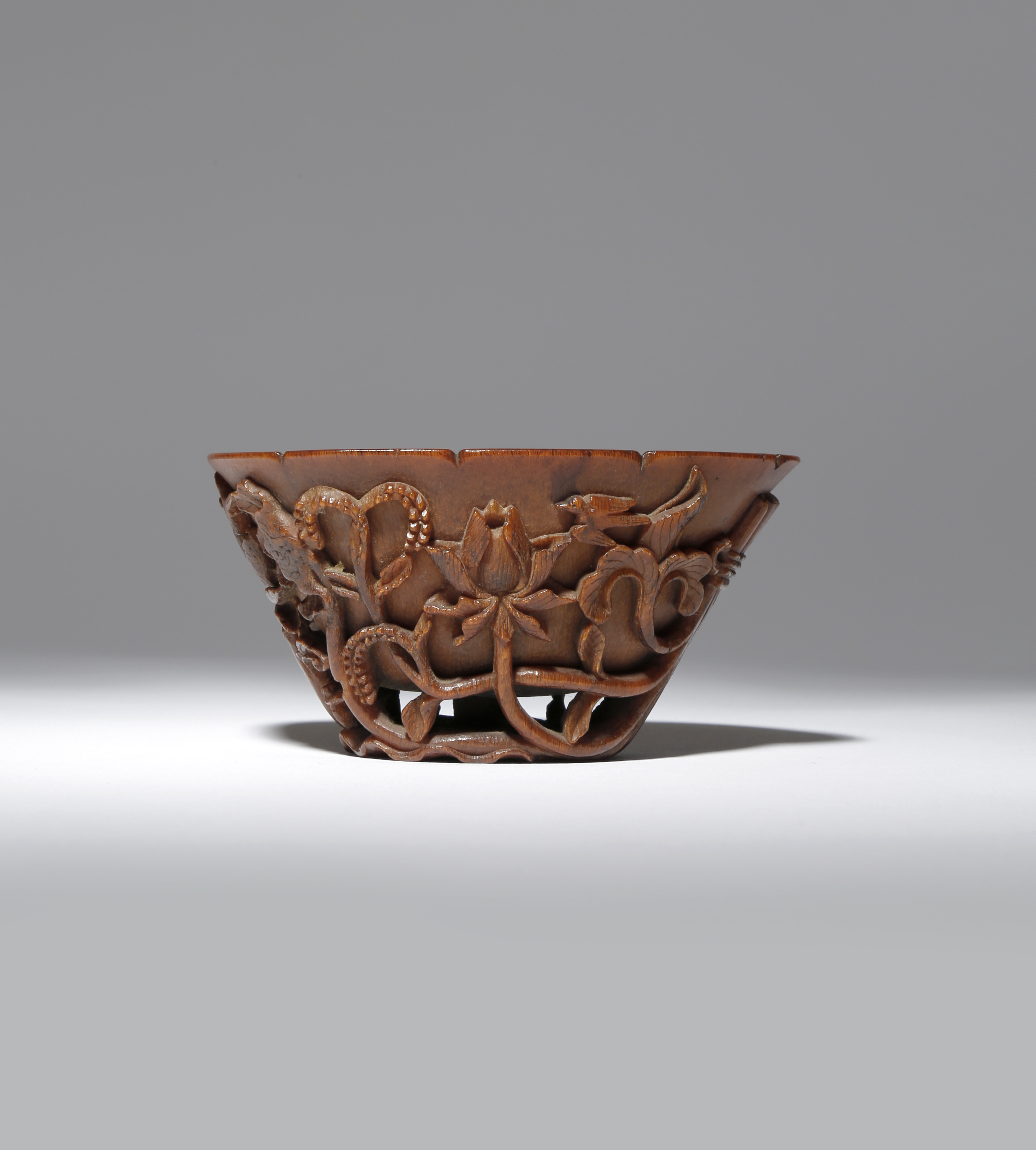 λ A CHINESE RHINOCEROS HORN 'LOTUS AND GRAIN' LIBATION CUP 18TH CENTURY The exterior carved in