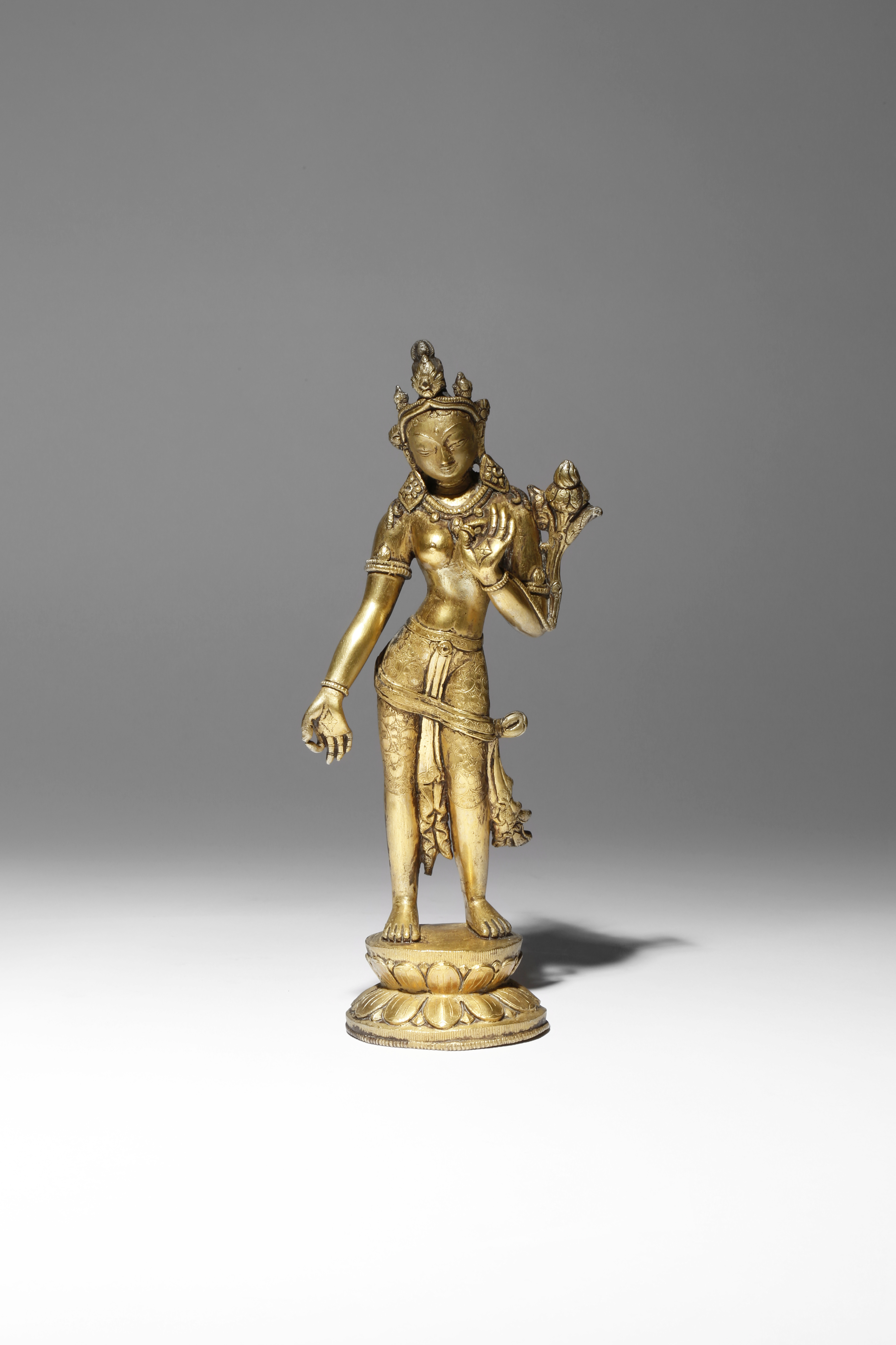 A TIBETAN GILT-BRONZE FIGURE OF PADMAPANI 18TH CENTURY Depicted standing in tribhanga upon a