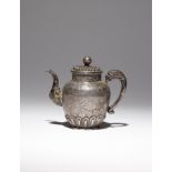 A TIBETAN REPOUSSE AND INCISED SILVER EWER AND COVER 19TH CENTURY Set with a makara-shaped spout and