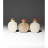 THREE CHINESE SNUFF BOTTLES 19TH CENTURY One carved in pale celadon jade with stylised flowerheads