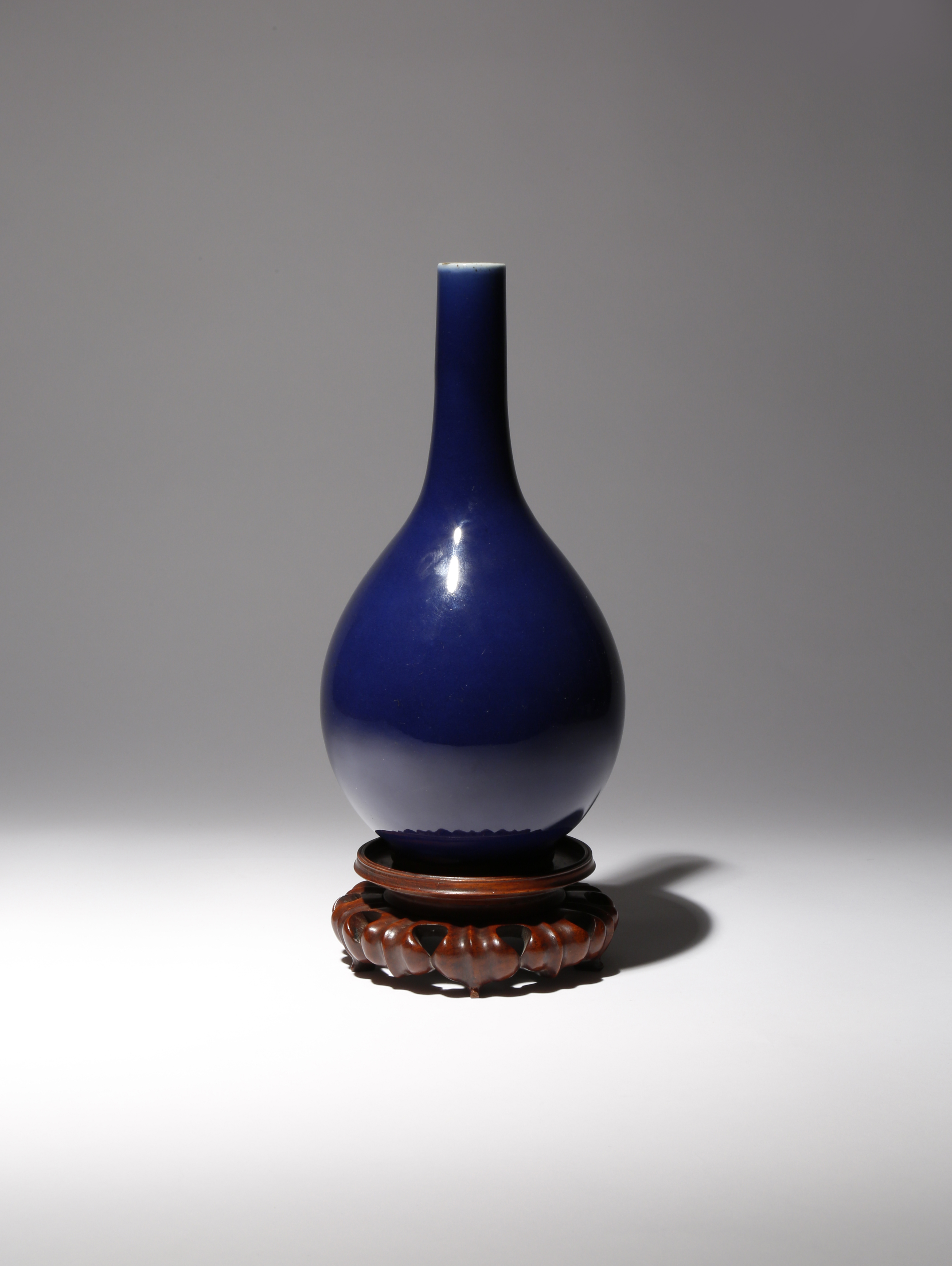 A CHINESE BLUE GLAZED BOTTLE VASE 18TH CENTURY The pear-shaped body surmounted by a tall narrow