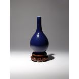 A CHINESE BLUE GLAZED BOTTLE VASE 18TH CENTURY The pear-shaped body surmounted by a tall narrow