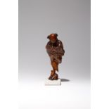 A CHINESE BURR WOOD FIGURE OF A BOY LATE QING DYNASTY Carved standing on a rock with his arms