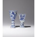 TWO CHINESE BLUE AND WHITE STEM CUPS KANGXI 1662-1722 One moulded with a ribbed body rising to a