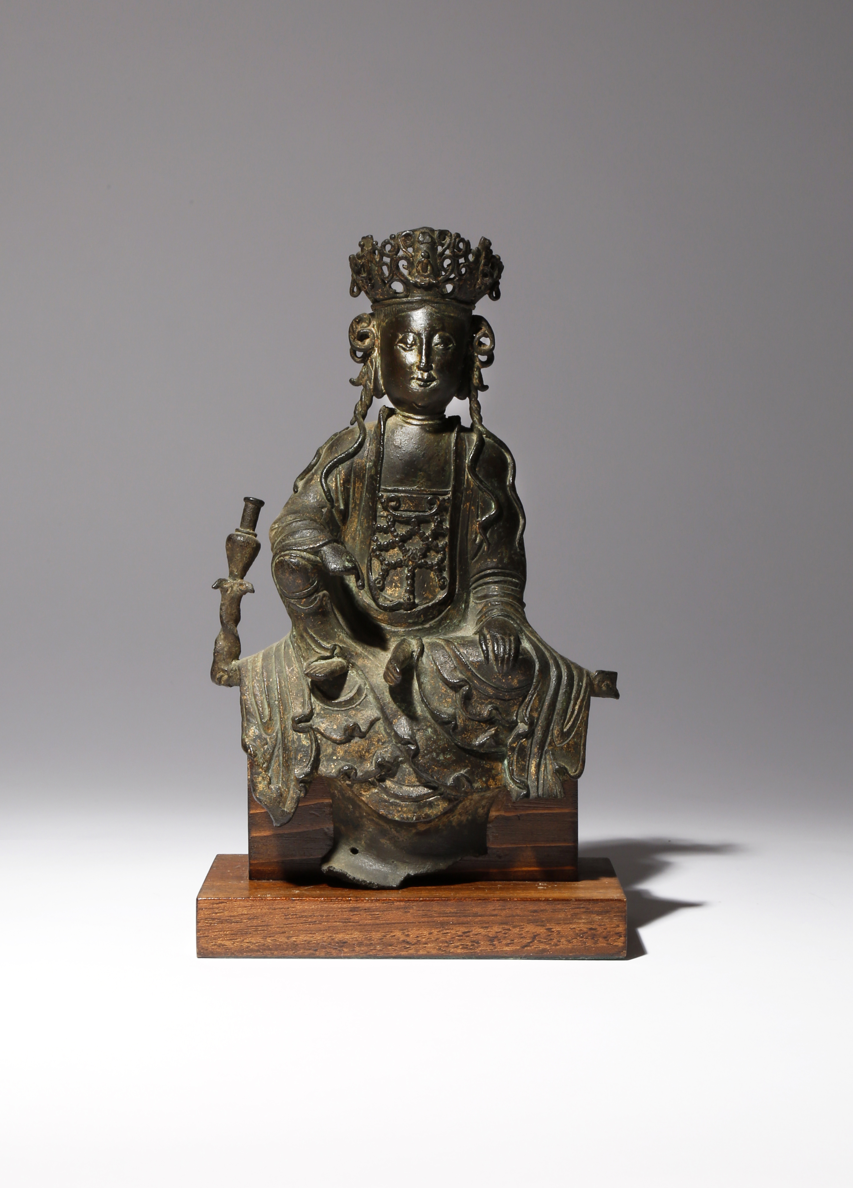 A CHINESE PARCEL-GILT BRONZE FIGURE OF GUANYIN MING DYNASTY She sits in a relaxed pose with her