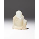 A CHINESE WHITE JADE CARVING OF A LUOHAN QING DYNASTY Depicted seated dressed in monk's robes, his