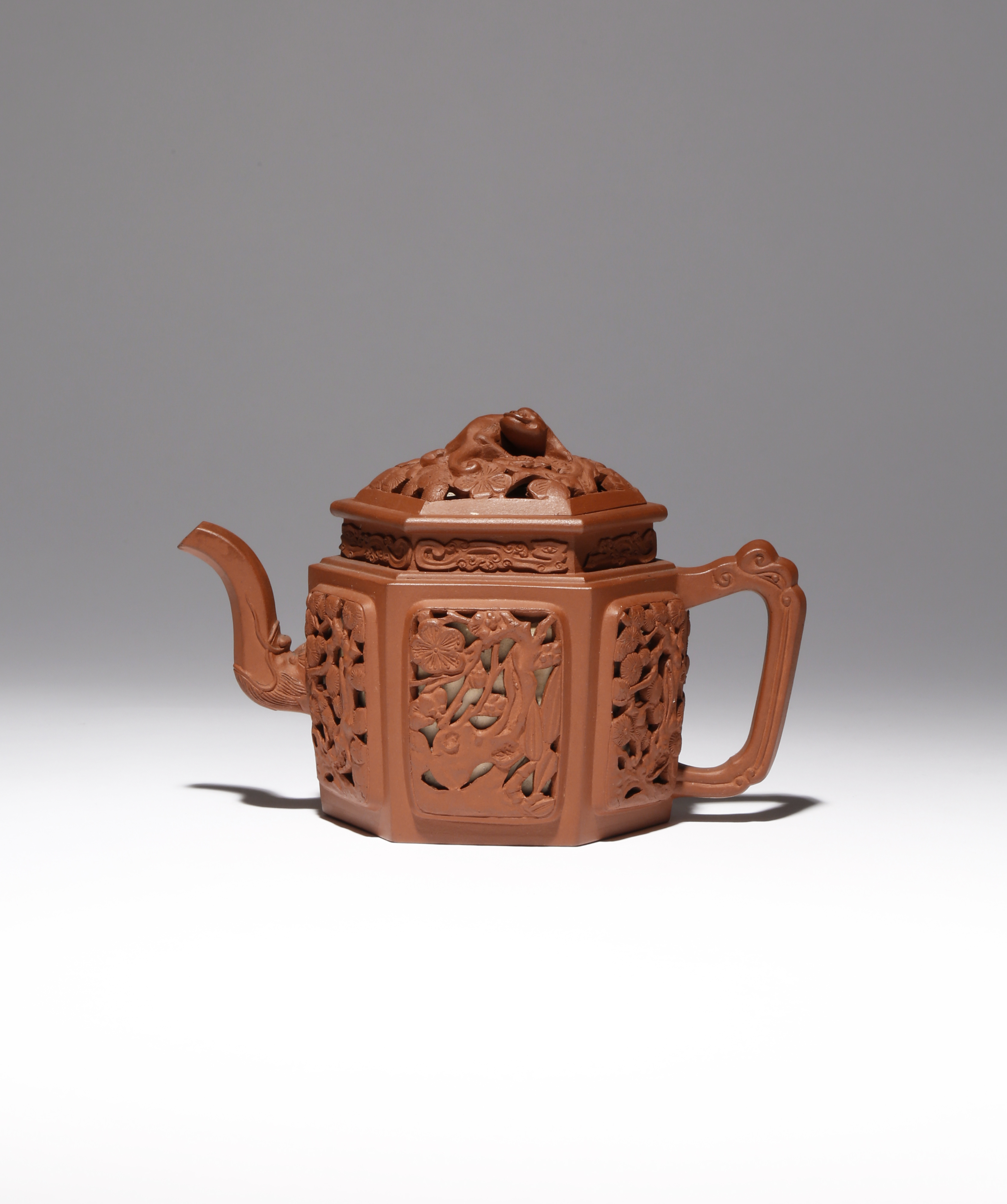 A CHINESE YIXING HEXAGONAL-SECTION TEAPOT AND COVER EARLY 18TH CENTURY Pierced to each facet with
