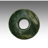 A CHINESE ARCHAISTIC SPINACH-GREEN JADE BI PROBABLY LATE QING DYNASTY The disc tapering at the