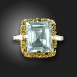 An aquamarine and diamond abstract ring, the rectangular step-cut aquamarine is set within