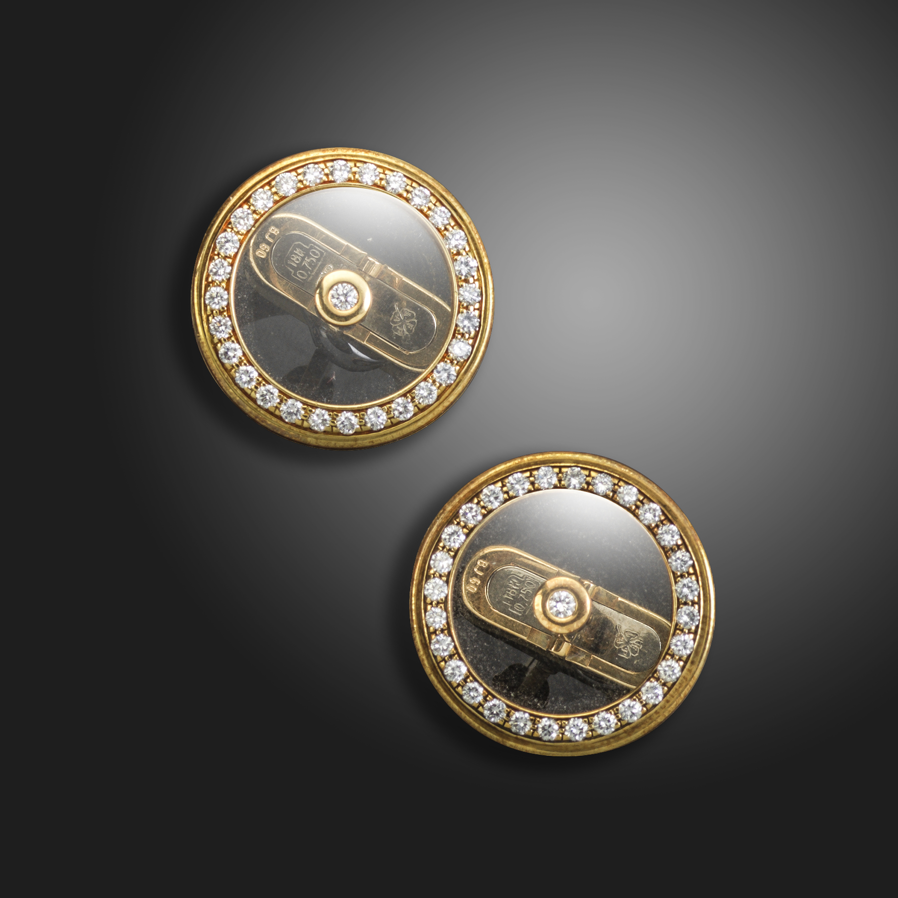 A pair of diamond and rock crystal circular cufflinks, the crystal discs each centred with a round