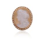 A Victorian carved hardstone cameo brooch, depicting Dionysus in profile, within seed pearl border