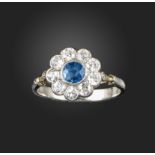 A sapphire and diamond cluster ring, the circular-cut sapphire set within a surround of old