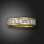 A diamond full-circle eternity ring, the princess-cut diamonds channel-set in wide yellow gold