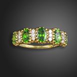 A demantoid garnet and diamond five-stone ring, the five graduated oval-shaped garnets are separated