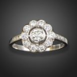 A diamond cluster ring, the round brilliant-cut diamond set within a surround of circular-cut