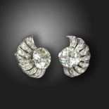 A pair of diamond scroll earrings, c.1940, each set with an old circular-cut diamond weighing