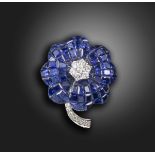 A sapphire and diamond-set flower pendant, centered with a cluster of round brilliant-cut diamonds,