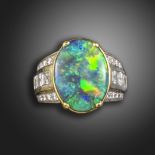 A black opal and diamond ring, the oval-shaped solid black opal is set within graduated lines of