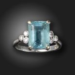 An aquamarine and diamond ring, the rectangular aquamarine is flanked with diamond trefoils in