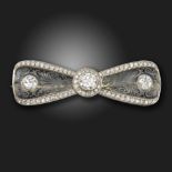 An Edwardian rock crystal and diamond bow brooch, centred with an old circular-cut diamond, the rock