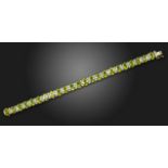 A peridot and diamond bracelet, set with oval-shaped peridots and rows of round brilliant-cut