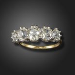A diamond five-stone ring, claw-set with graduated old cushion-shaped diamonds in platinum and gold,