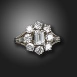 A mid 20th century diamond cluster ring, set with an emerald-cut diamond weighing approximately 0.