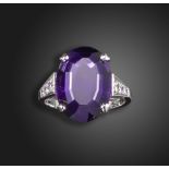 An amethyst and diamond ring, centred with an oval-shaped amethyst with graduated round brilliant-