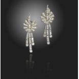 A pair of diamond drop earrings, the stylised bow sections suspend three asymmetrical articulated