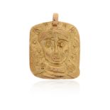 A gold medallion pendant, the square pendant depicting the abstract portrait of a woman in