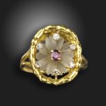 A gem-set flowerhead ring by John Donald, the rock crystal flower set with a ruby centre within an