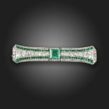 An Art Deco emerald and diamond brooch, centred with a square-shaped emerald, within a surround of