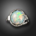 An Art Deco opal and diamond cluster ring, the oval-shaped opal set within a surround of small