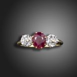 An early 20th century ruby and diamond three stone ring, the oval-shaped ruby weighs 1.82cts,