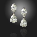 A pair of diamond drop earrings, each marquise-shaped diamond suspends a pear-shaped diamond in