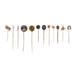 A cased set of twelve stick pins, including a rose-cut diamond-set circular pin in silver on gold, a