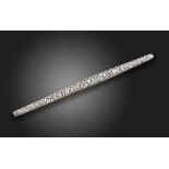 An early 20th century diamond bar brooch, set with graduated old circular-cut diamonds in