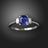 A sapphire and diamond three-stone ring, set with an emerald-cut sapphire weighing approximately 1.