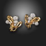 A pair of diamond and gold scroll earrings, c.1950, the pave-set diamond semi-spheres set within