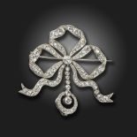 An Edwardian diamond-set bow brooch, the sylised bow millegrain-set with graduated old cushion-