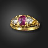 A pink sapphire and diamond three stone ring, the oval-shaped pink sapphire set with rose-cut