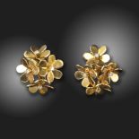 A pair of diamond-set gold foliate earrings, each rotating flowerhead centred with a round