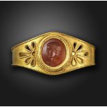 A late 19th century Archaological Revival gold scarf ring by Wiθse, set with a Roman carnelian