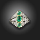 An emerald and diamond ring, set with three graduated oval-shaped emeralds, with graduated old