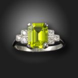 A peridot and diamond ring, set with an emerald-cut peridot with round brilliant-cut shoulder