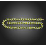 A peridot and diamond necklace, set with oval-shaped peridots and rows of round brilliant-cut