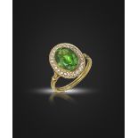 A demantoid garnet and diamond cluster ring, the oval-shaped demantoid garnet weighs 3.13cts, set