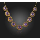 A Regency composite amethyst and gold necklace, the graduated oval-shaped amethysts are set within