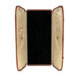 A leather fitted parure case by Cartier, the centre-opening box with fitted sections for a necklace,