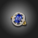A sapphire and diamond cluster ring, the cushion-shaped sapphire weighs approximately 8.079cts,